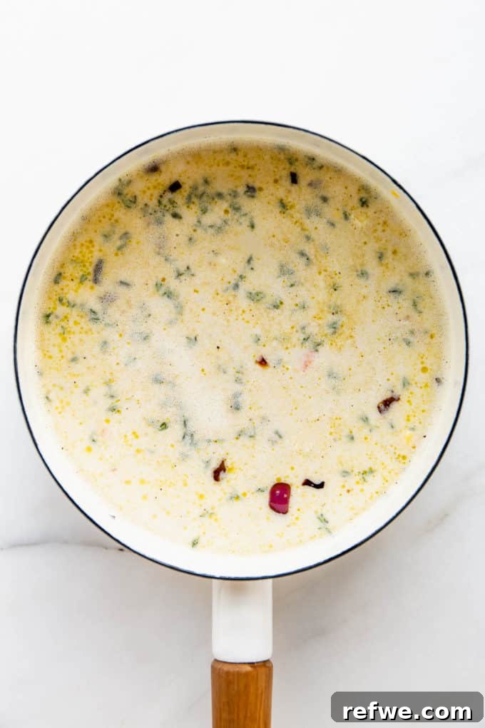 Creamy Vegan Corn Chowder 7 A white pot with vegetable broth and cashew cream added, simmering