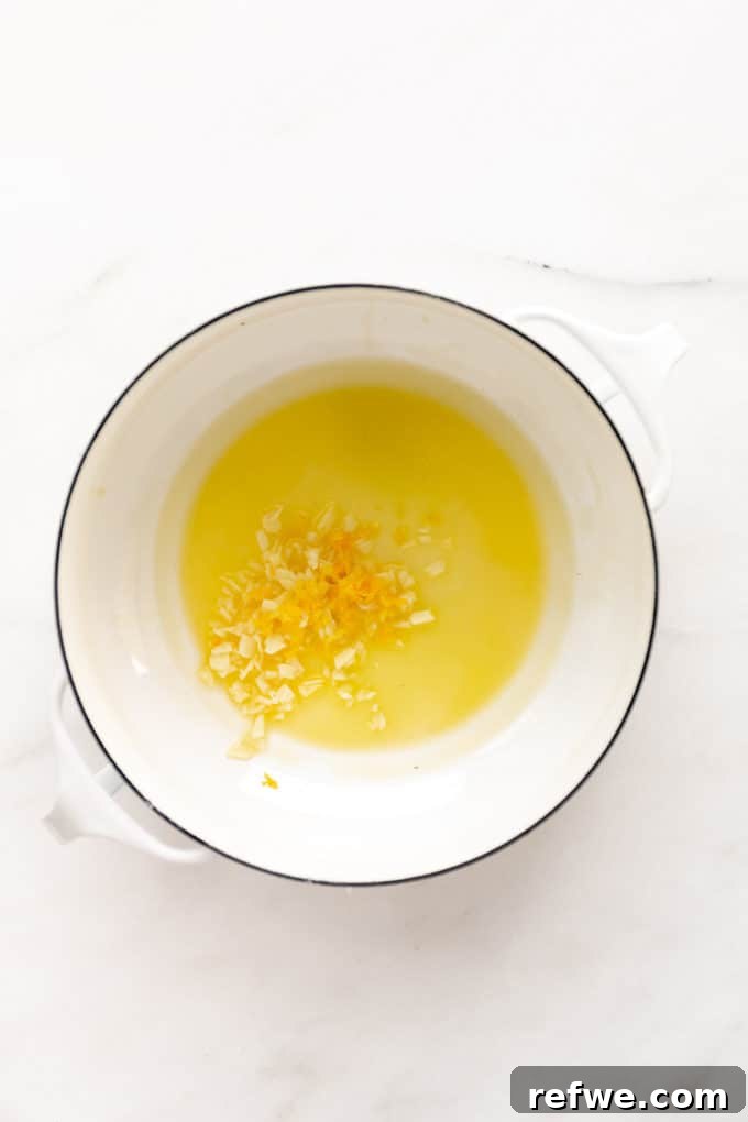 Zesty Lemon Garlic Pasta 4 Melted oil and butter with fragrant minced garlic and lemon zest simmering gently in a white pot, releasing their aromas