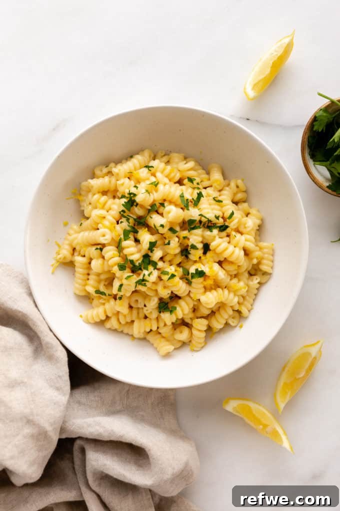 Zesty Lemon Garlic Pasta 10 A beautifully plated bowl of lemon pasta, garnished with fresh herbs and sliced lemons on the side, ready to be enjoyed