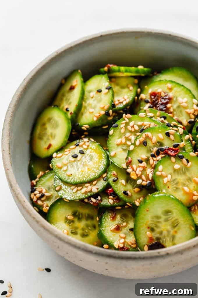 A vibrant Asian cucumber salad, elegantly served in a bowl and generously adorned with toasted sesame seeds, ready for enjoyment.