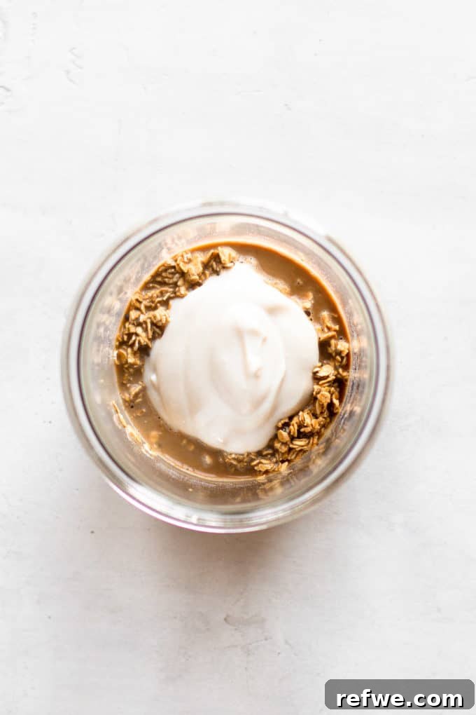 Java Overnight Oats 6 A close-up view of creamy oats, coffee, and yogurt perfectly blended together in a clear cup, showcasing its inviting texture.