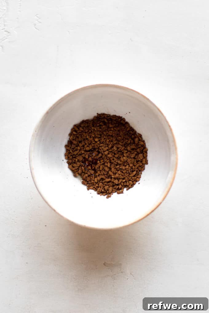 Java Overnight Oats 8 A small bowl holding dark instant coffee granules, perfectly measured and ready to be mixed for the whipped coffee cream.