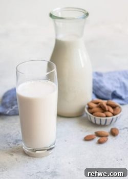 Beautiful homemade almond milk in a glass bottle with whole almonds