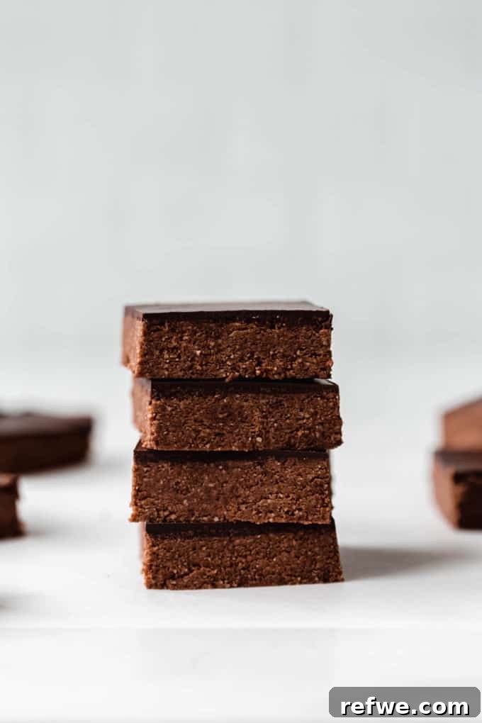 Effortless Fudgy Chocolate Protein Bars 3 A beautifully arranged stack of four homemade chocolate protein bars, demonstrating their appealing presentation and tempting layers.