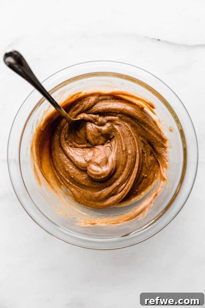 Effortless Fudgy Chocolate Protein Bars 5 Creamy almond butter waiting in a mixing bowl, a key binding agent for the protein bars.