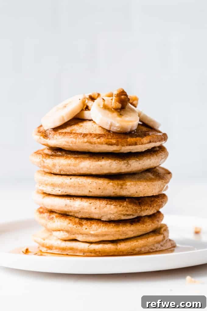 Wholesome Oat Flapjack Feast 12 A beautifully arranged stack of six oat flour pancakes topped with sliced bananas and walnuts