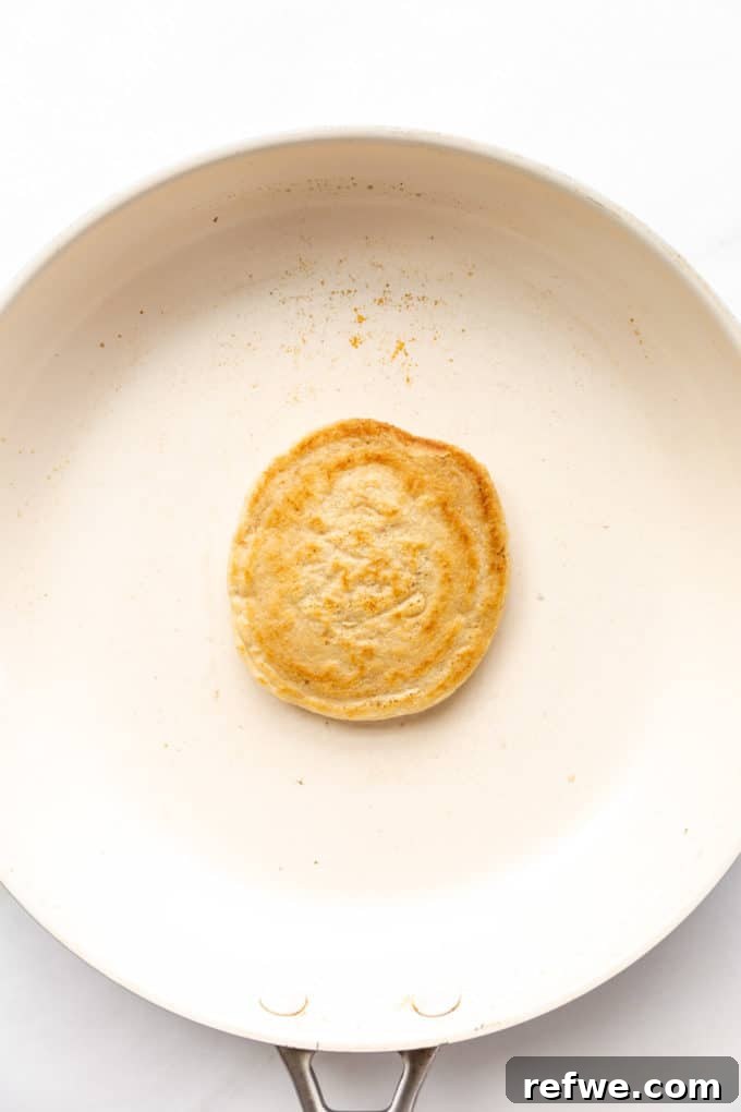 Wholesome Oat Flapjack Feast 10 A perfectly cooked, golden brown oat flour pancake in a white pan