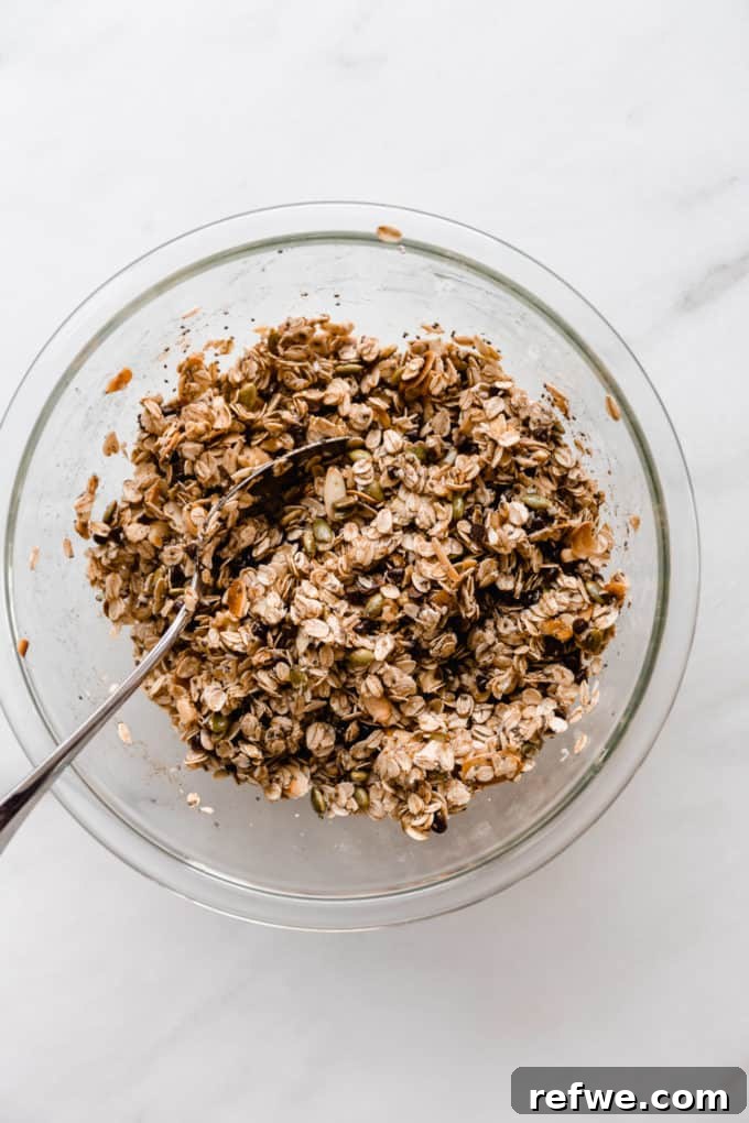 Wholesome Energy Muesli Bars 6 The muesli bar ingredients in a mixing bowl, now fully combined with the wet mixture, showing a sticky, cohesive texture.
