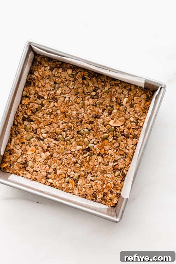 Wholesome Energy Muesli Bars 8 Freshly baked muesli bars, golden brown and perfectly firm, still in the square pan, cooling.