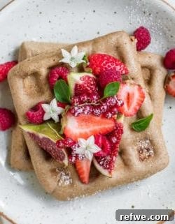 Stacked vegan buckwheat waffles with berries.