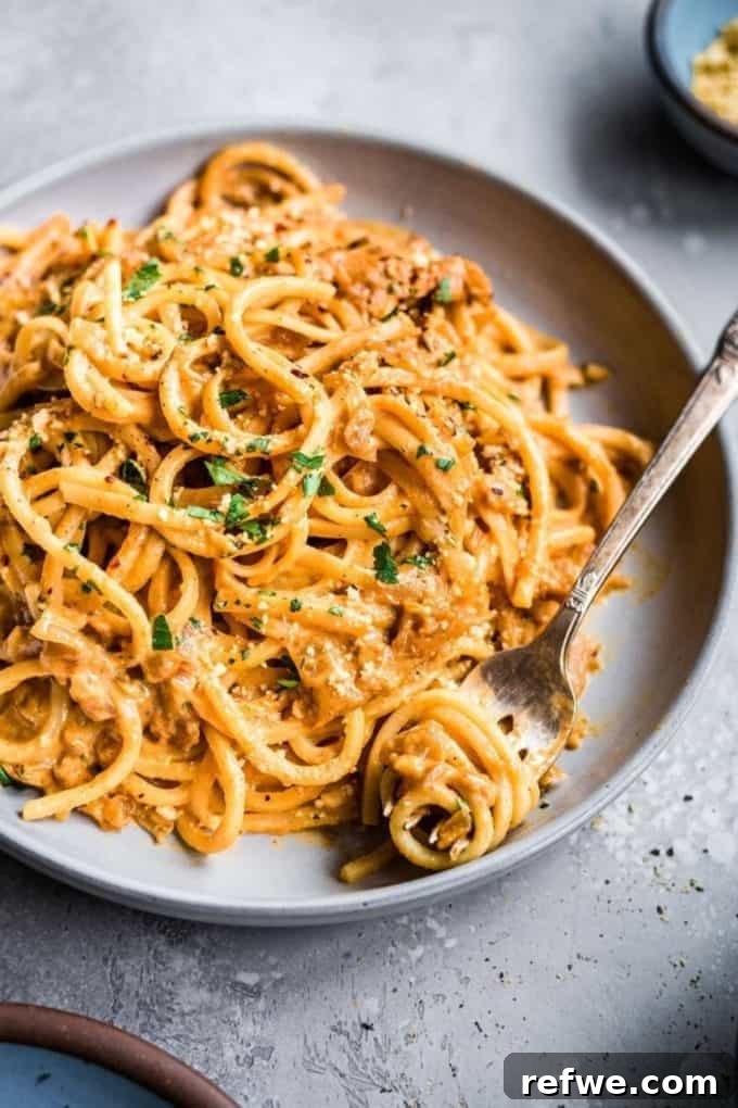 31 Irresistible Vegan Pasta Dishes 13 Creamy spaghetti served on a sleek grey plate with a fork, highlighting its inviting texture.
