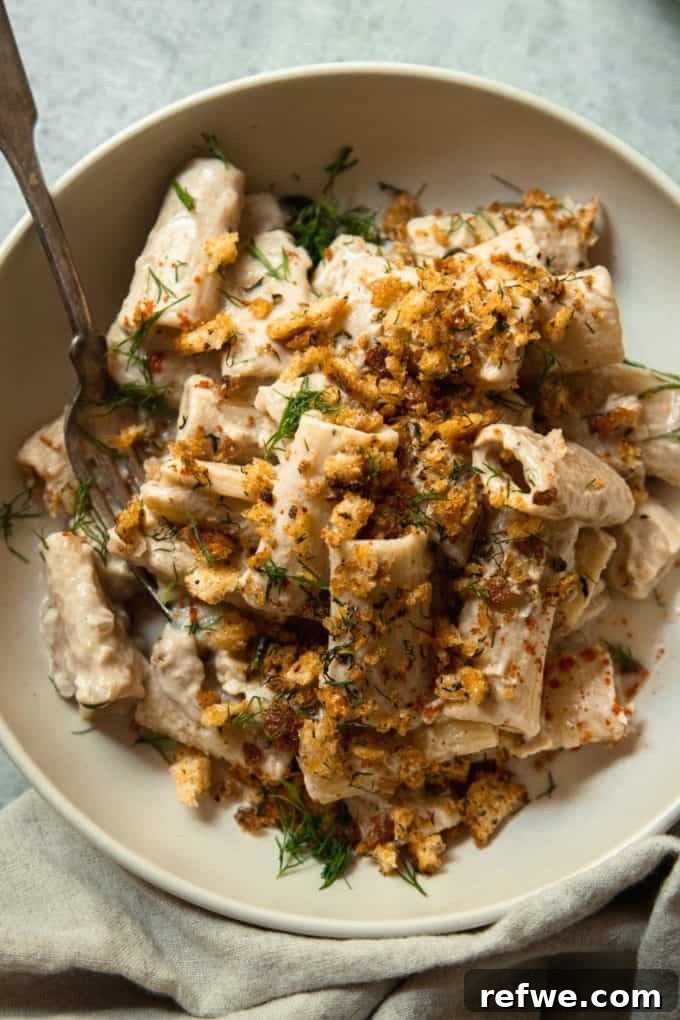 31 Irresistible Vegan Pasta Dishes 14 Rigatoni in a luxurious creamy sauce, elegantly topped with crispy breadcrumbs in a chic beige bowl.
