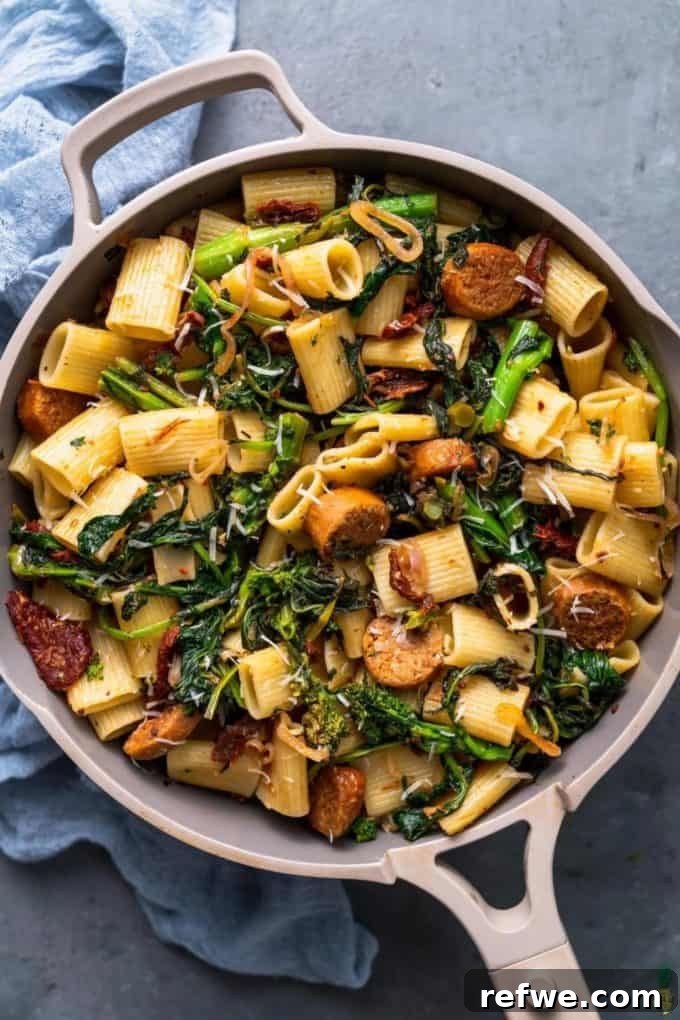 31 Irresistible Vegan Pasta Dishes 25 Rigatoni pasta expertly combined with sautéed broccoli rabe and savory vegan sausage in a stylish grey pan.
