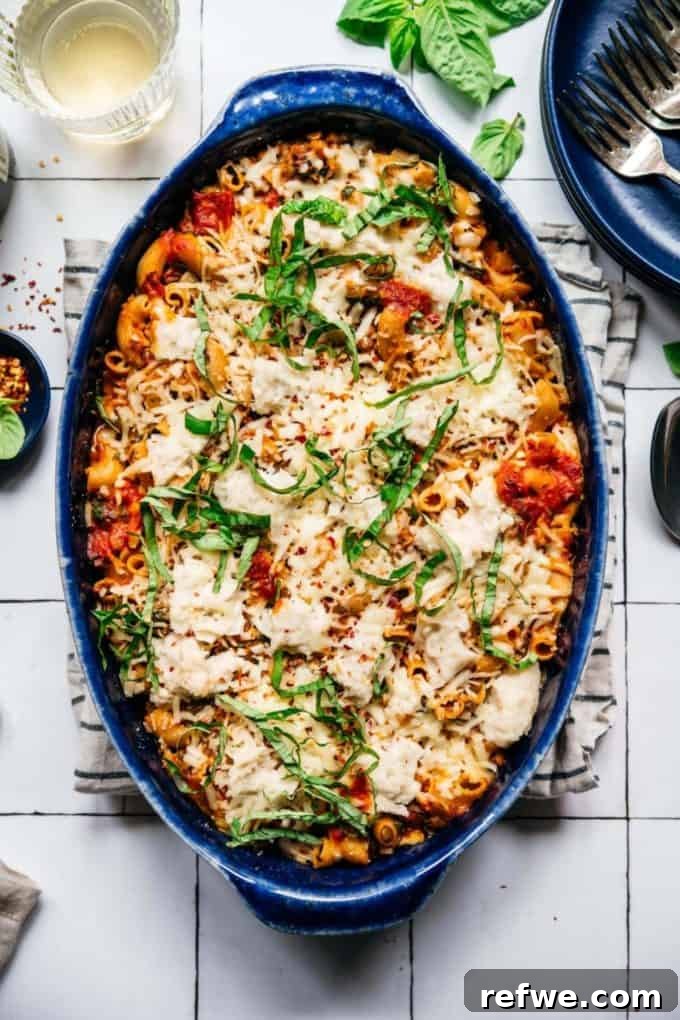 31 Irresistible Vegan Pasta Dishes 32 A vibrant blue baking dish filled with a delicious vegan pasta bake, garnished with fresh basil leaves.