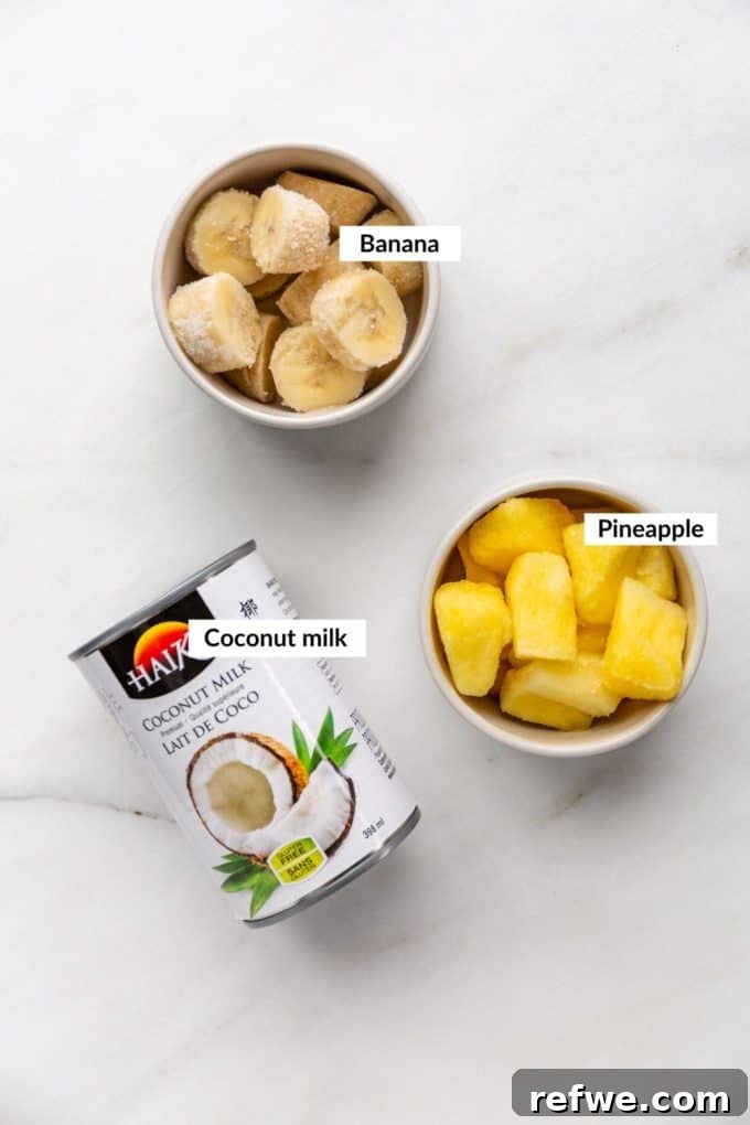 Pina Colada Dream Smoothie 3 Fresh pineapple chunks, ripe bananas, and canned coconut milk displayed as core ingredients for a tropical smoothie.