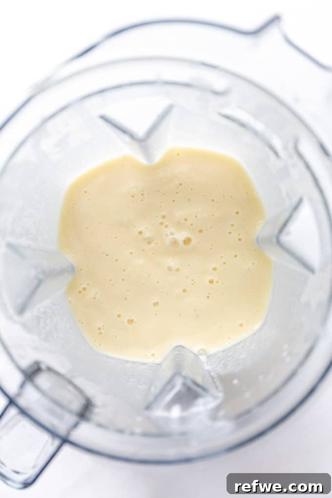 Pina Colada Dream Smoothie 5 A perfectly blended Pina Colada Smoothie swirling inside a blender pitcher, showcasing its creamy, uniform texture.