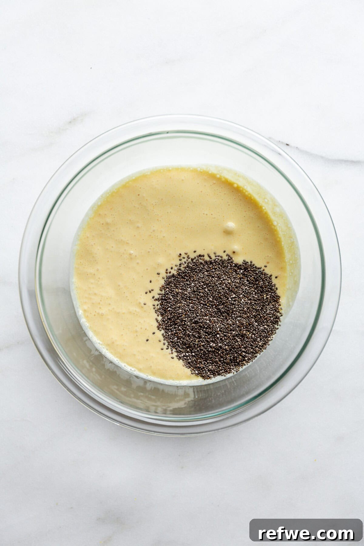 Sunshine Lemon Chia Pudding 6 Chia seeds and the blended lemon cream mixture in a clear mixing bowl, ready to be combined.
