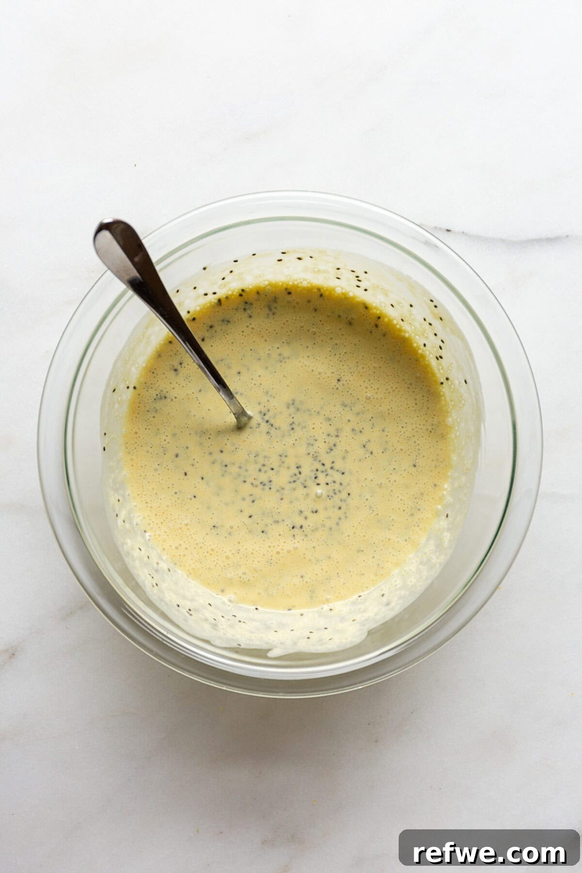 Sunshine Lemon Chia Pudding 7 Unchilled lemon chia pudding mixture in a mixing bowl after the chia seeds have been incorporated.