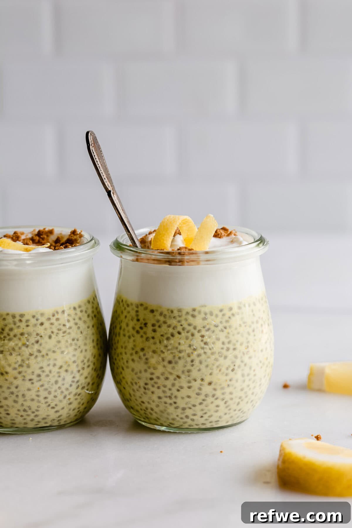 Sunshine Lemon Chia Pudding 9 Two cups of lemon chia pudding, one topped with yogurt and lemon zest, the other with graham cracker crumbs and a lemon twist.