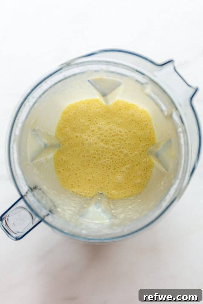 Paradise Pina Colada Pops 5 Smooth, blended pineapple and coconut milk mixture in a blender, ready for freezing.