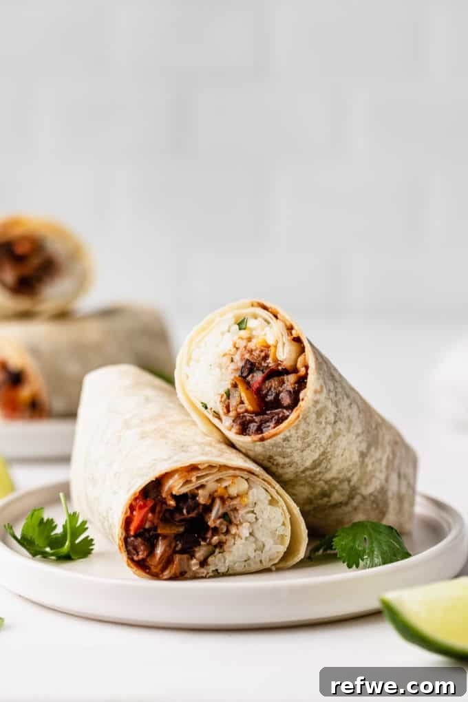 A freshly rolled veggie burrito, perfectly presented on a white plate and garnished with a sprig of fresh cilantro.