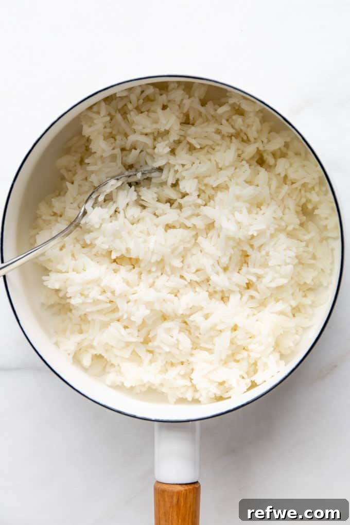 Fluffy white rice cooking in a pristine white pot on a stovetop, capturing its steamy aroma.