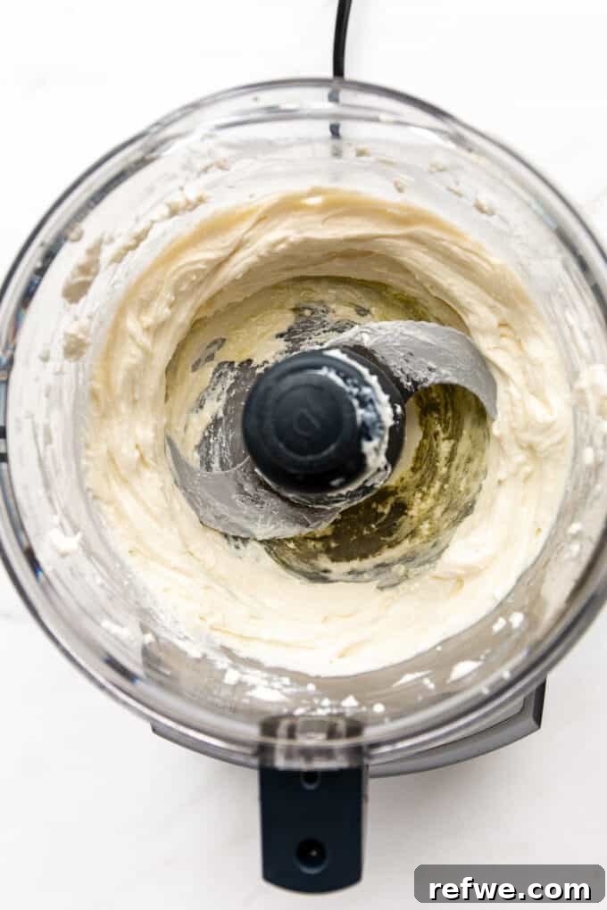 Pillowy Ricotta Toast 4 Whipped ricotta in a food processor after blending, showing its smooth, airy texture.