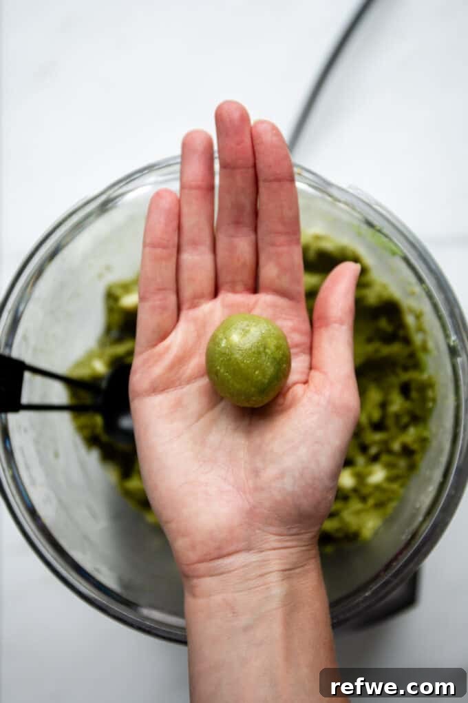 Zen Matcha Fuel Bites 6 a perfectly formed matcha energy ball held in a hand, showing its smooth texture