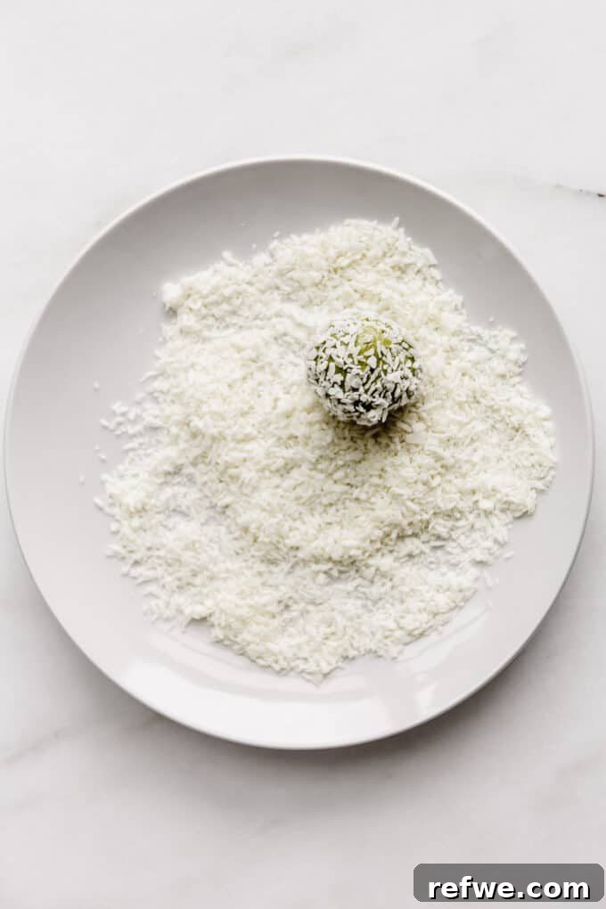 Zen Matcha Fuel Bites 7 a matcha energy ball being rolled in a plate of shredded coconut for coating