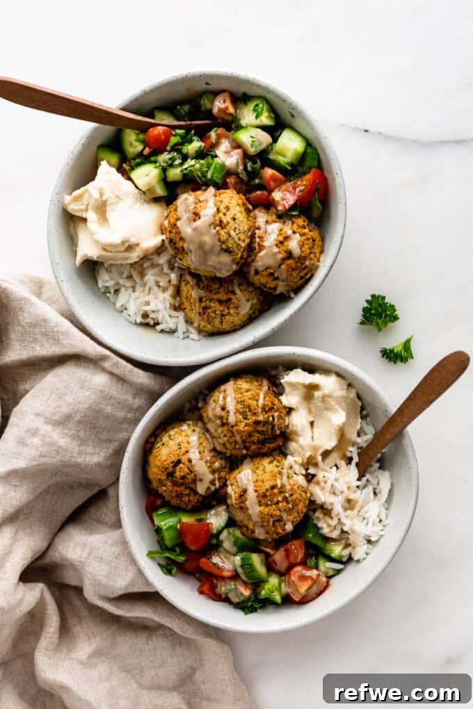 Quick Oven-Baked Falafel Bowls 2 Two falafel bowls with wooden spoons in them, showcasing a vibrant, healthy meal