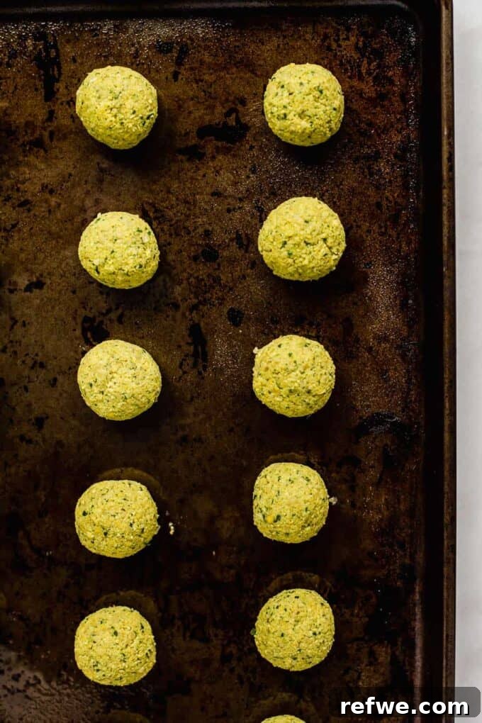 Quick Oven-Baked Falafel Bowls 5 Unbaked falafel balls neatly arranged on a baking sheet