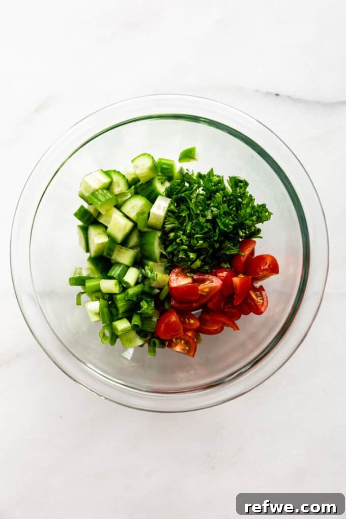Quick Oven-Baked Falafel Bowls 7 Diced cucumber, fresh parsley, and grape tomatoes in a clear mixing bowl