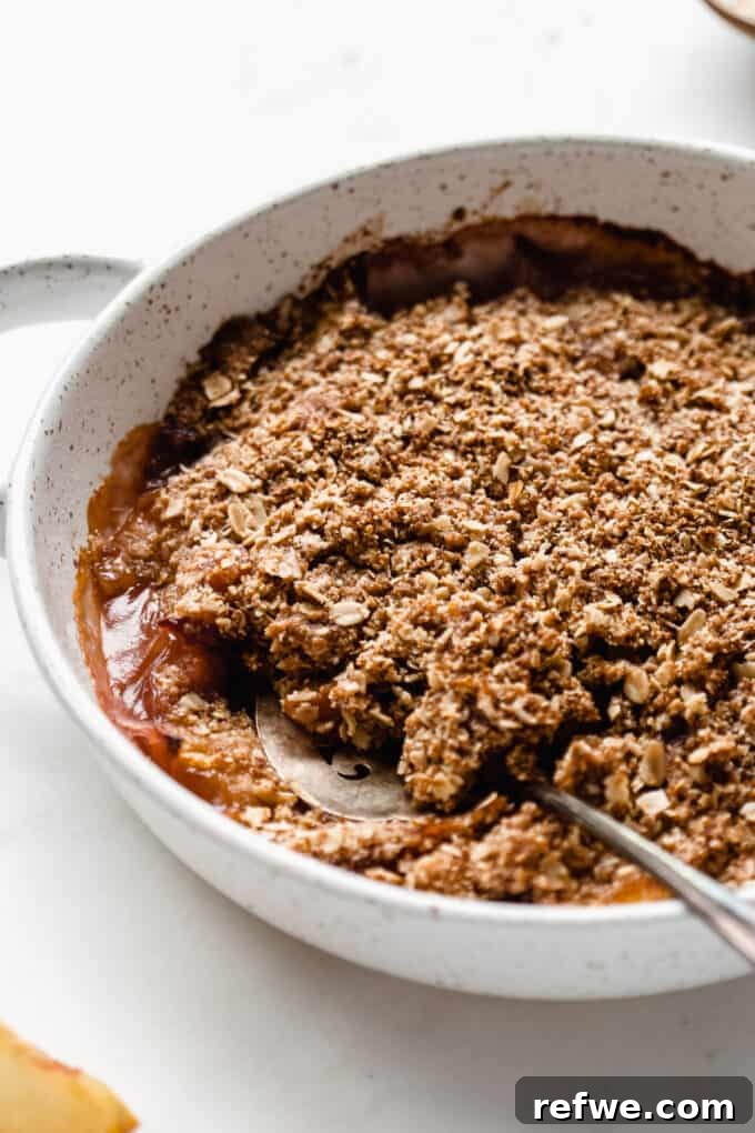 A close-up view of the delicious gluten-free peach crisp, still warm in its baking dish, ready to be served.