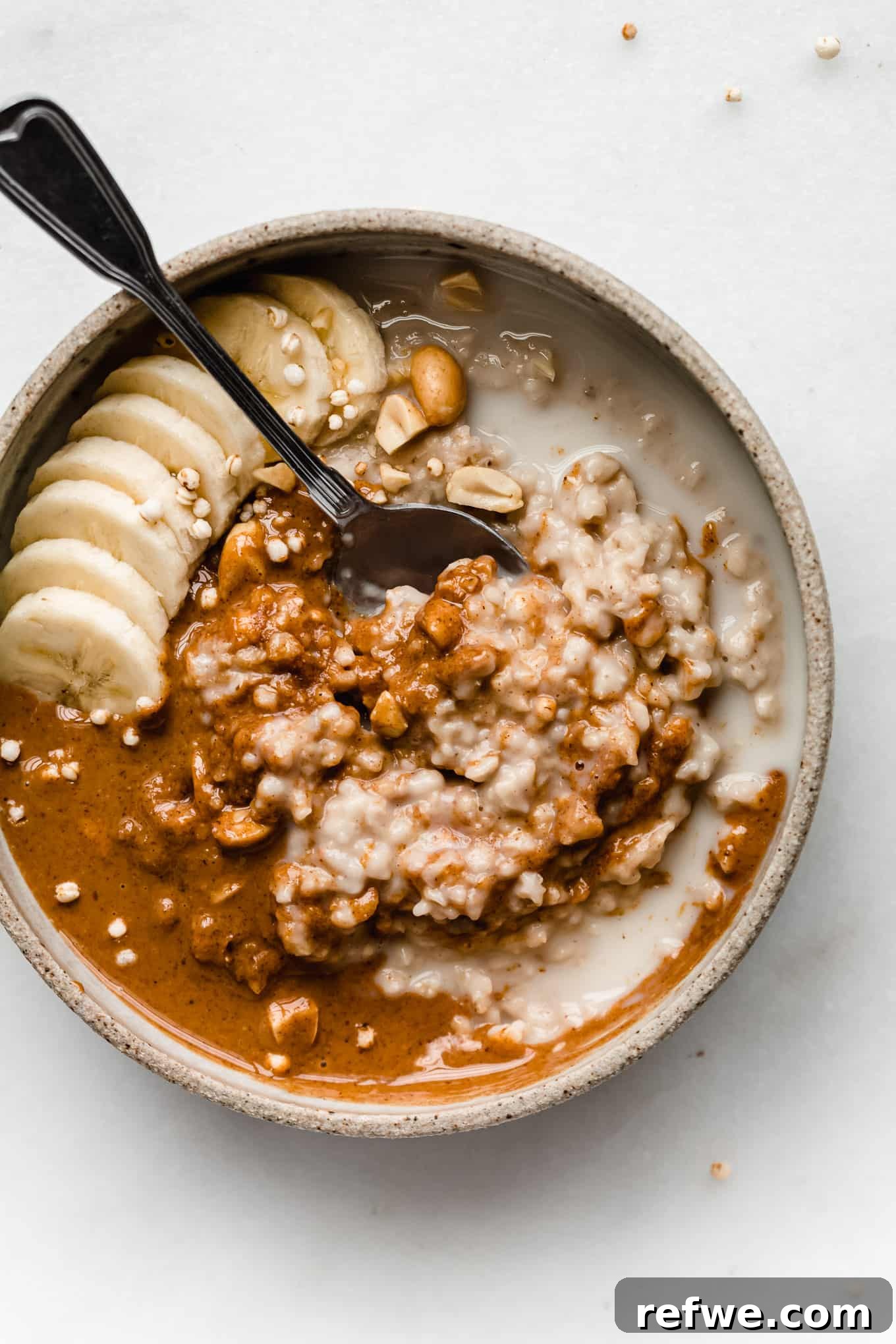 Nutty Oatmeal Delight 2 A beautifully presented bowl of creamy peanut butter oatmeal, garnished with sliced bananas and a drizzle of extra peanut butter.