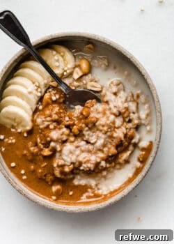 A bowl of peanut butter oatmeal with bananas on top, styled for a recipe card.