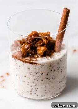 Apple Pie Overnight Oats topped with stewed apples in a white glass jar, ready for a healthy and delicious breakfast.