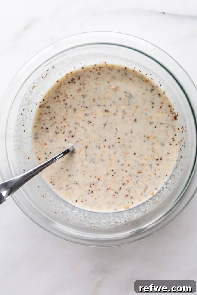 No-Bake Apple Pie Oats 6 The oat mixture, including chia seeds and almond milk, thoroughly mixed in a clear bowl, ready for refrigeration.
