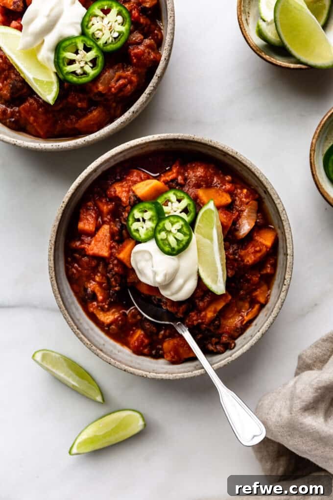 Hearty Sweet Potato Black Bean Chili 11 Two bowls of sweet potato chili, generously topped with a swirl of sour cream, ready to be enjoyed.