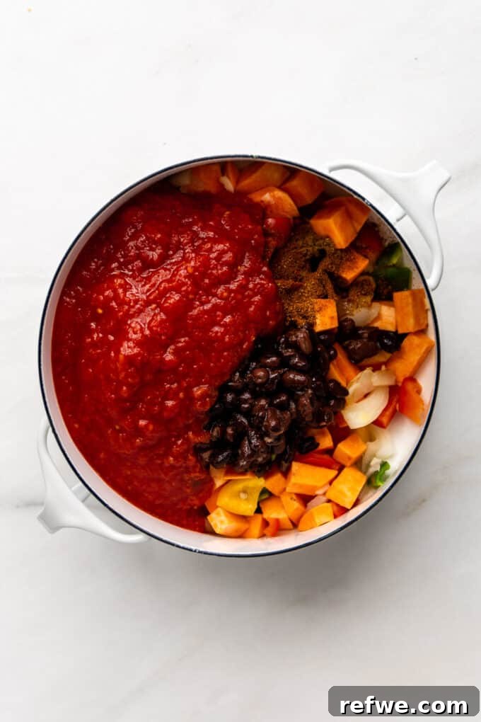 Hearty Sweet Potato Black Bean Chili 8 Crushed tomatoes and vegetable broth added to the pot of vegetables, sweet potatoes, and black beans.