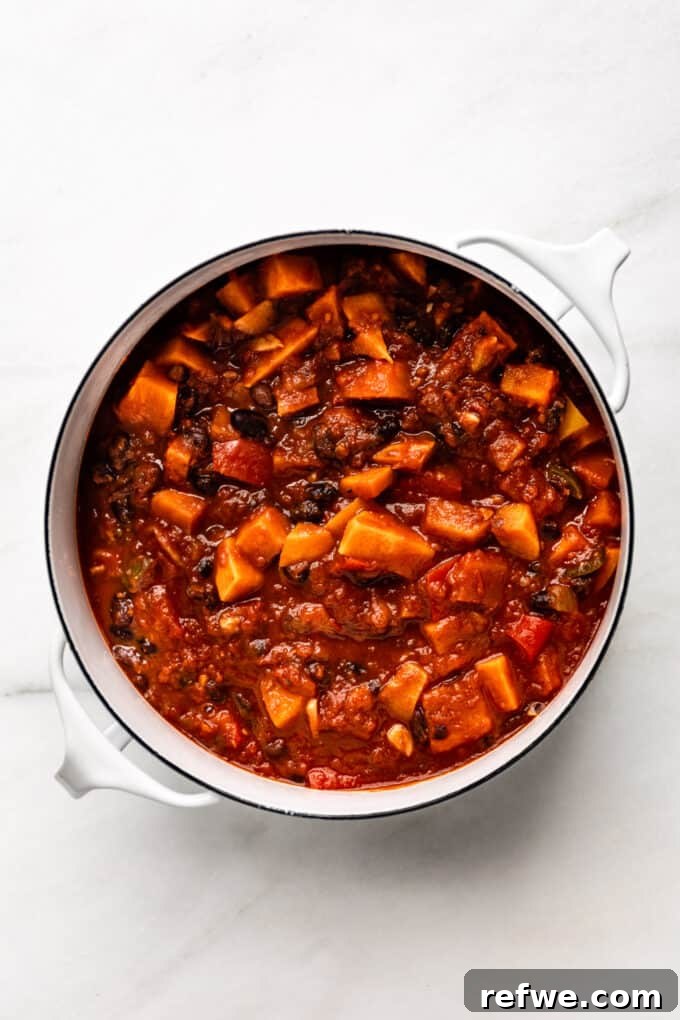 Hearty Sweet Potato Black Bean Chili 9 A large pot of simmering sweet potato chili, rich and thick, on the stovetop.