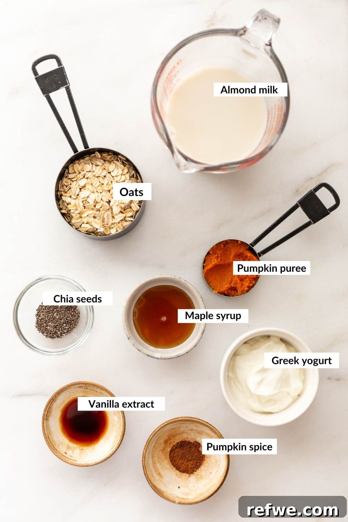 Overnight Autumn Pumpkin Delight 3 A flat lay of key ingredients for pumpkin pie overnight oats, including rolled oats, pumpkin puree, chia seeds, and spices.