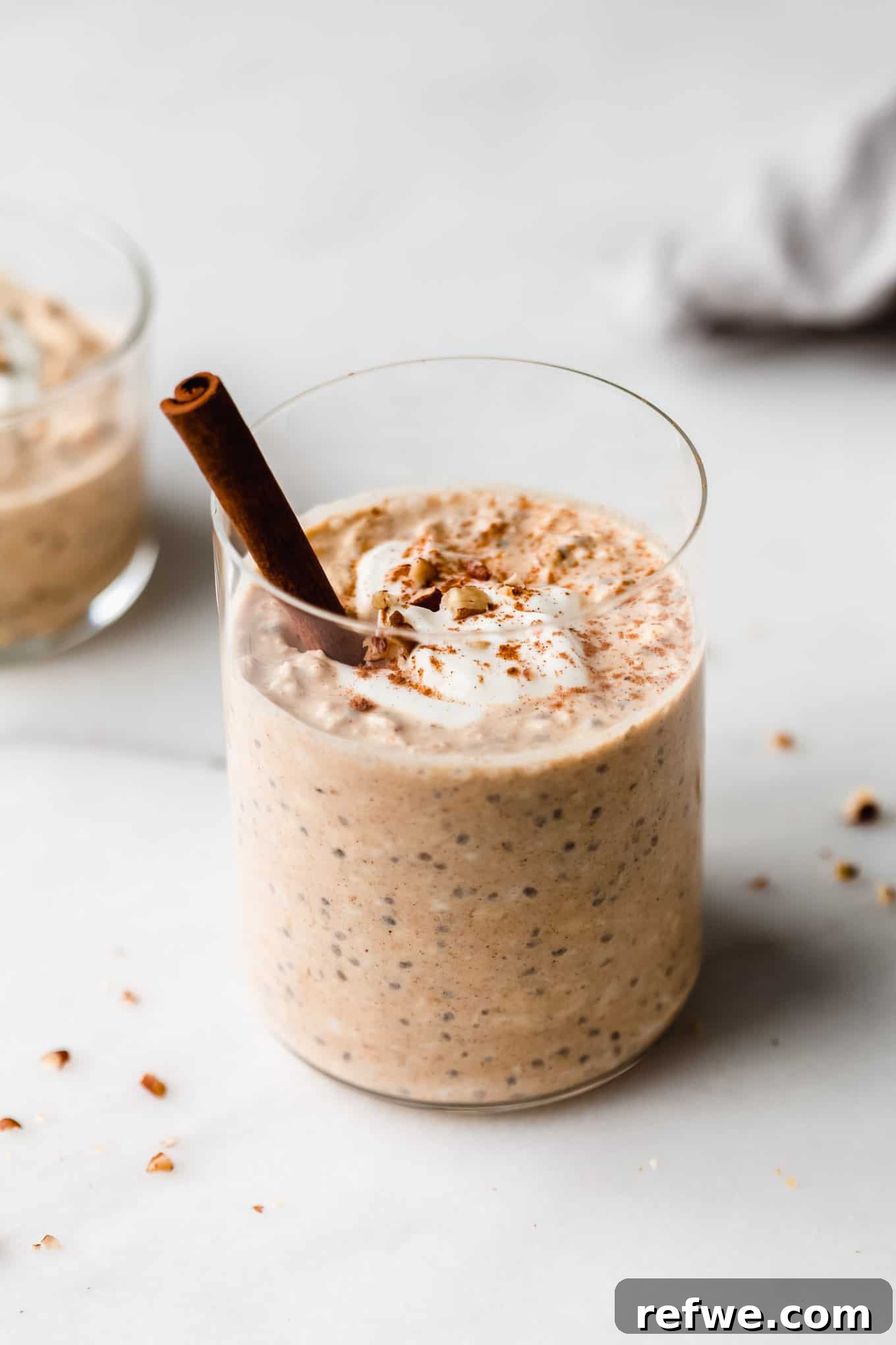 Overnight Autumn Pumpkin Delight 8 Creamy overnight pumpkin oats in a clear cup, topped with a dollop of yogurt and chopped walnuts, ready to eat.