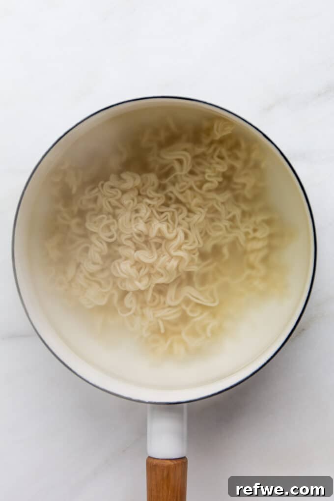 Ramen noodles boiling in a pot of water, perfectly separating as they cook.