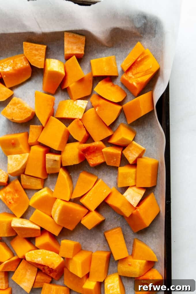 cubed butternut squash and sweet potato on a baking sheet, ready for roasting