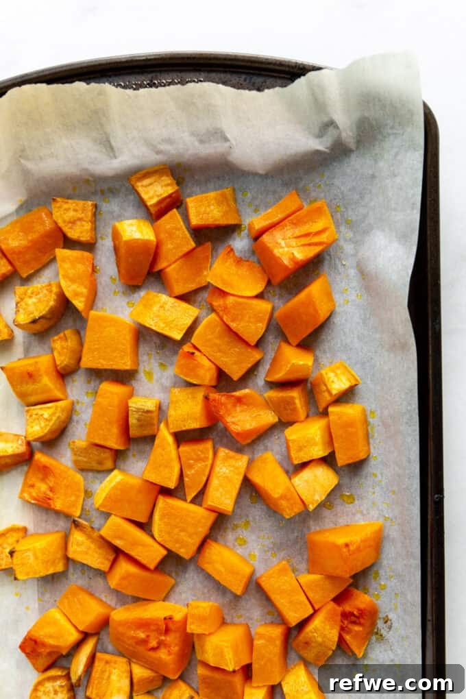 golden brown roasted butternut squash and sweet potato on a baking sheet