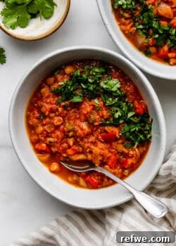 A bowl of lentil chili garnished with fresh cilantro, indicating a delicious and healthy plant-based meal.