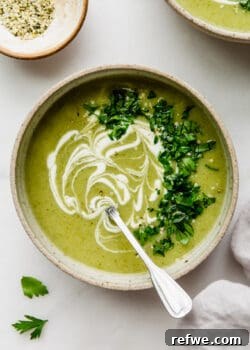 Broccoli potato soup in a bowl with sour cream and parsley