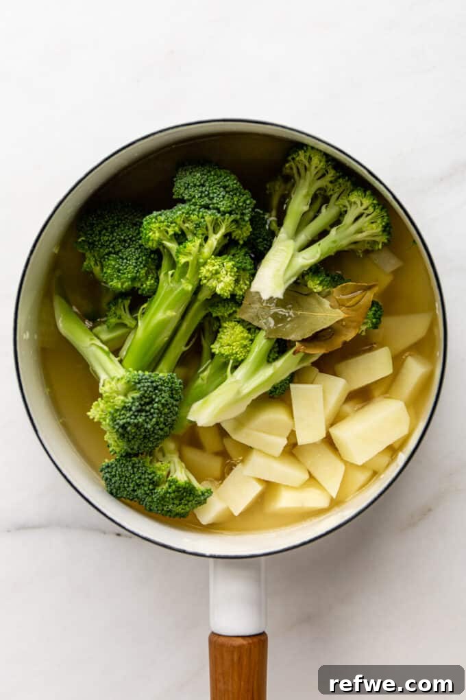 Wholesome Broccoli Potato Potage 7 Broccoli, potato, and bay leaves simmering in vegetable broth in a white pot