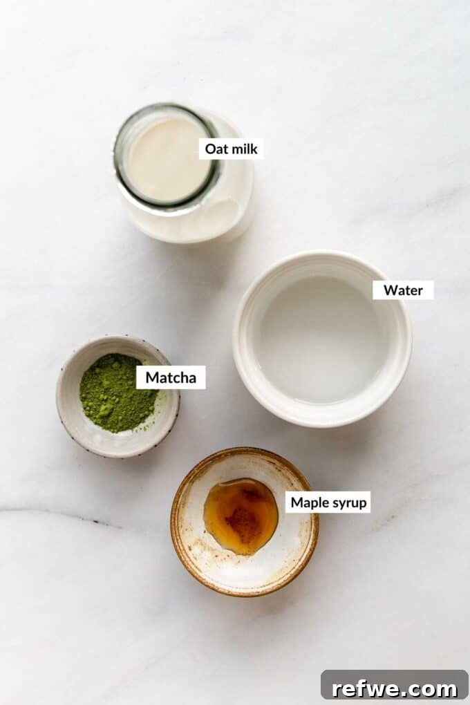 A selection of fresh ingredients laid out for making a matcha latte, including matcha powder, milk, and sweetener.