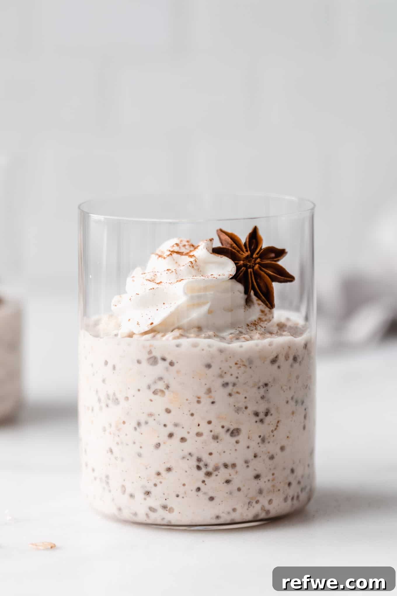 a cup of chai latte overnight oats topped with whipped cream